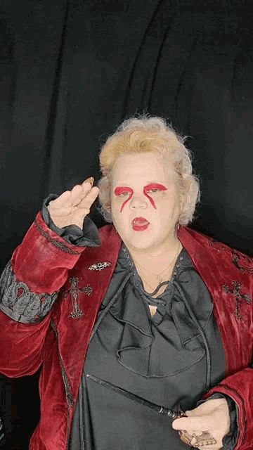a woman wearing a red jacket with a cross on the sleeve