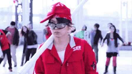 a woman wearing a red jacket and a red hat is holding a white object .