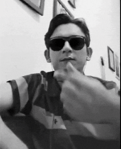 a man wearing sunglasses is giving a thumbs up sign .