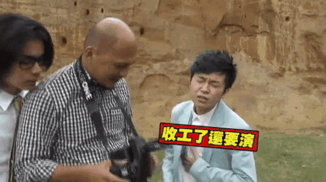 a man in a suit is holding a camera with a canon strap around his neck