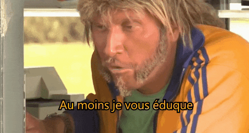 a man with blonde hair and a beard is wearing a yellow and blue jacket with the words au moins je vous eduque above him