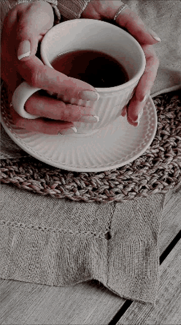 a woman is holding a cup of coffee in her hands