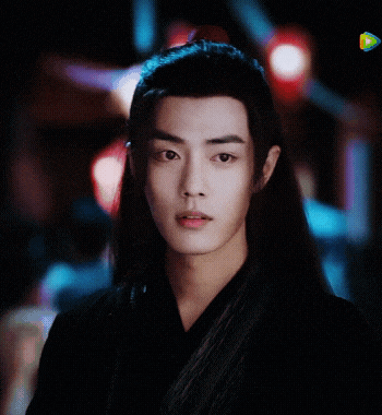 a young man with long black hair is wearing a black kimono .