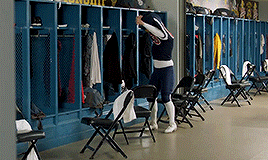 a person standing in a locker room with a sign on the wall that says ' u.s. army '