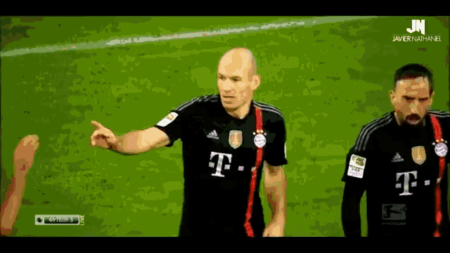 a man in a black t-mobile jersey stands on a field