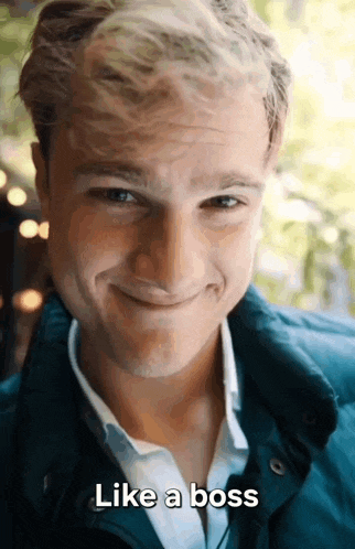 a man in a blue jacket is smiling and says " like a boss "