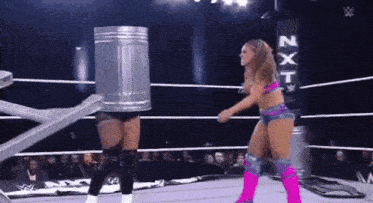 a woman in a wrestling ring with a trash can on her head .