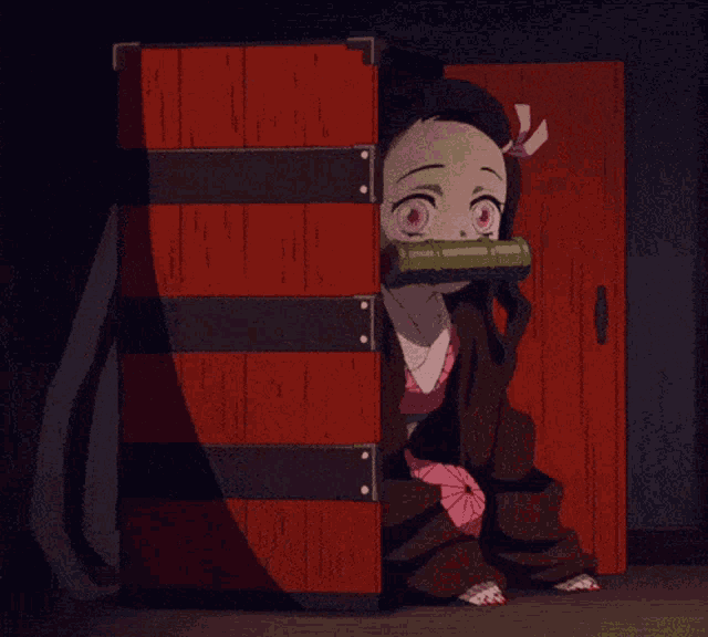 a little girl is sitting in a red box