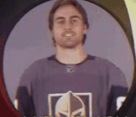 a man is wearing a purple jersey with a helmet on it