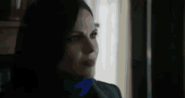 a close up of a woman wearing a blue scarf and a black jacket .