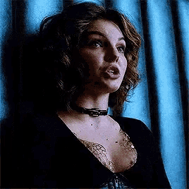 a woman is wearing a choker and a plunging neckline .