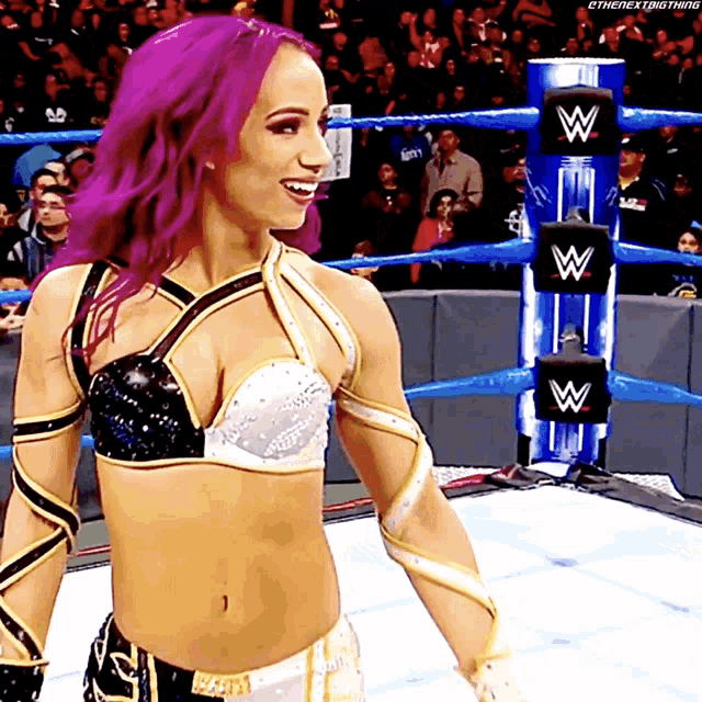 a woman with purple hair is standing in a wrestling ring with the letter w on it