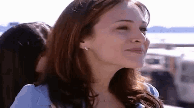 a close up of a woman 's face with a smile on her face and a woman behind her .