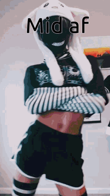a person wearing bunny ears and a mask with the words mid af written on it