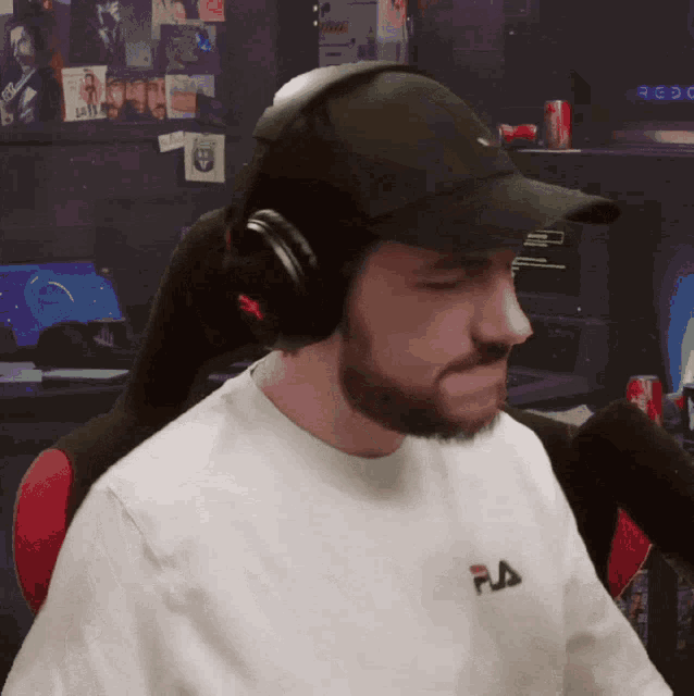 a man wearing headphones and a white shirt with fila on the front