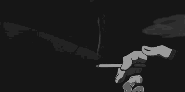 a person is holding a cigarette in their hand in a black and white photo .