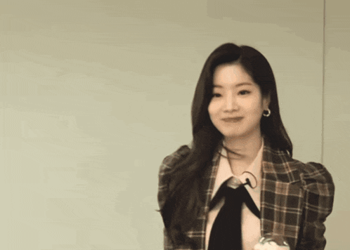 a woman wearing a plaid jacket and a bow tie
