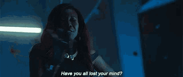 a woman with red hair is standing in a dark room .