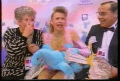 a woman in a pink dress is crying while holding a stuffed animal