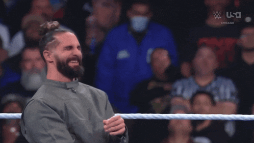 a man in a wrestling ring giving a thumbs up in front of a crowd that says usa