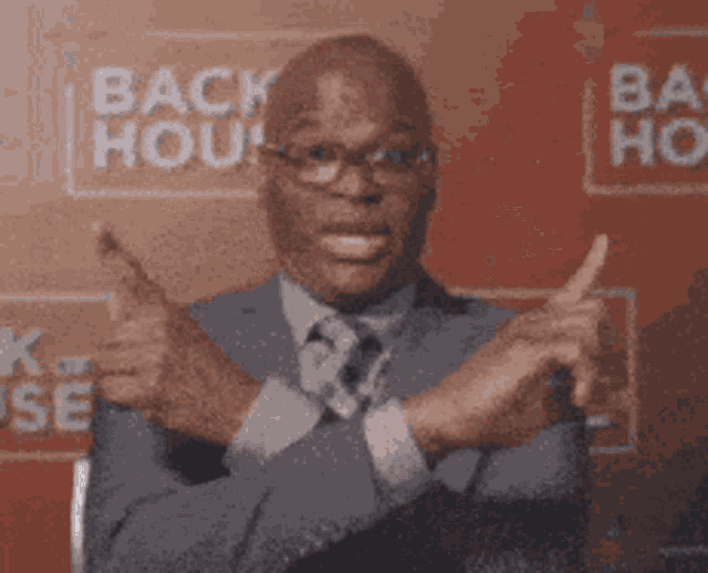 a man in a suit and tie is making a funny face with the word fam written on his hand