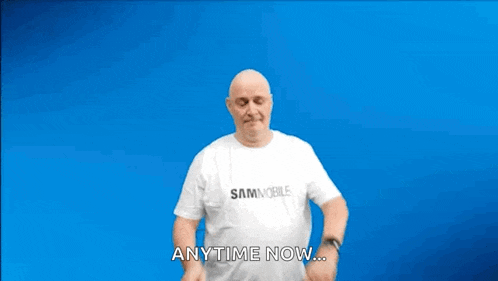 a bald man wearing a white shirt that says sammobile is dancing on a blue background .