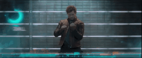 a man in a leather jacket is standing in front of a wall with the word quill on it