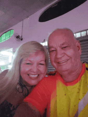 a man and woman are posing for a picture and the man is wearing a yellow shirt