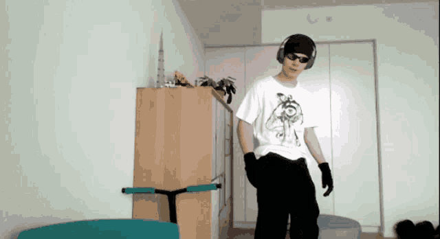 a young man wearing headphones and sunglasses is standing in a room
