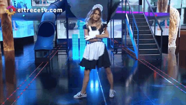 a woman in a maid costume is dancing on a stage