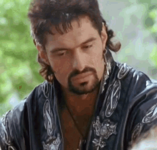 a man with a beard and a mullet is wearing a kimono and earrings .