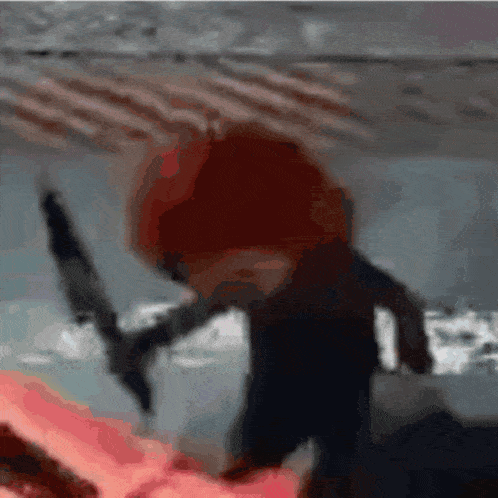 a person with red hair is holding a knife