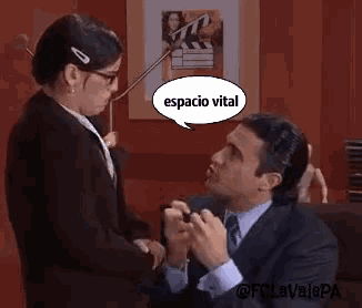 a man in a suit and tie is proposing to a woman with a speech bubble that says espacio vital