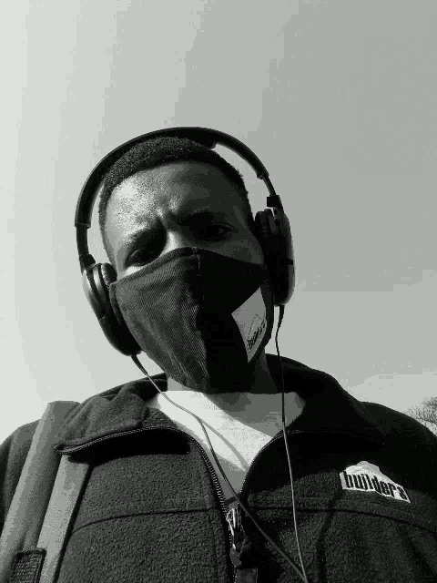 a man wearing a mask and headphones is wearing a jacket that says builders