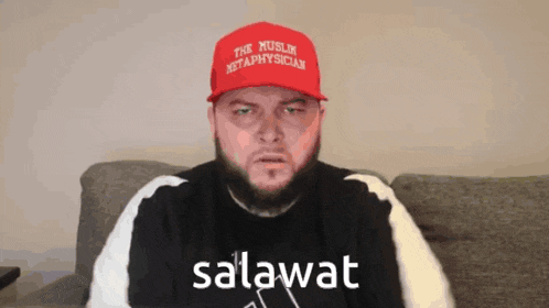 a man with a beard wearing a red hat that says " the muslim metaphysician "