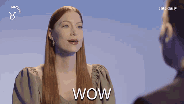 a woman with long red hair says wow in front of a man