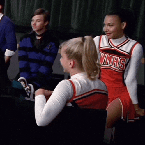 a cheerleader from wmhs sits next to another cheerleader in a chair