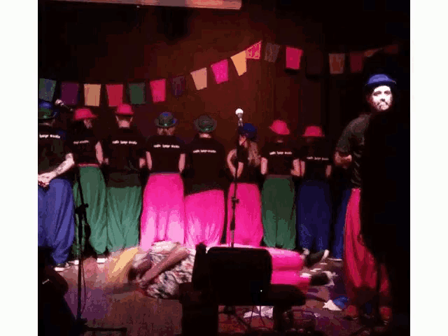 a group of people standing on a stage with one wearing a shirt that says ' i love you ' on the back