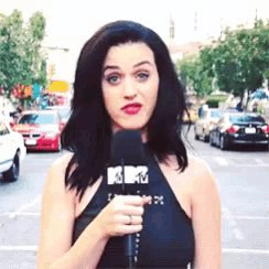 a woman is holding a microphone that has the letters mtv on it