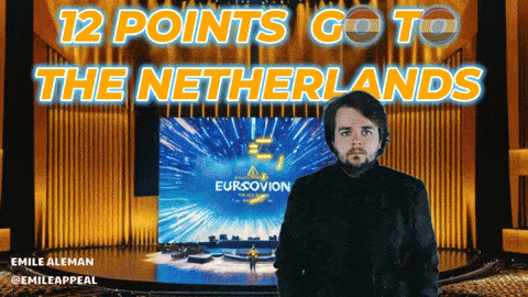 a man is standing in front of a large screen that says eurovision
