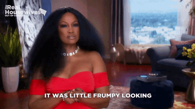 a woman in a red dress says it was little grumpy looking in a living room