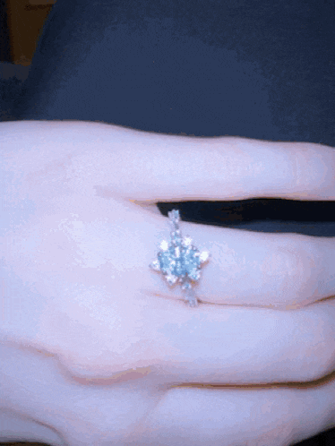 a woman 's hand with a ring on her finger