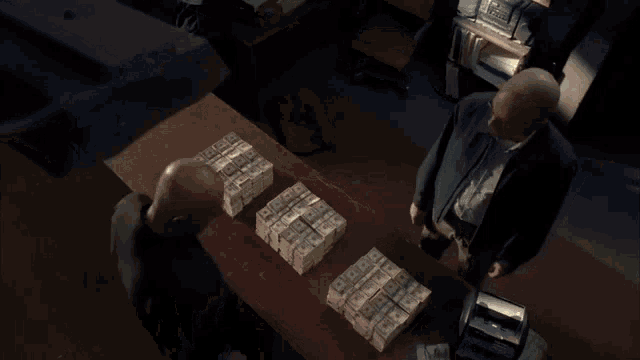 a man is standing in front of a stack of money .