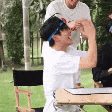 a man wearing a headband with the letter s on it sits in a director 's chair