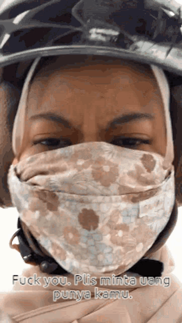 a woman wearing a helmet and a mask says fuck you plis minta uang punya kamu