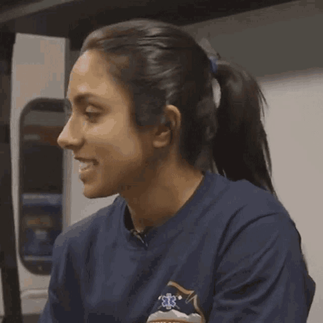 a woman in a blue shirt with the word yeah on her face