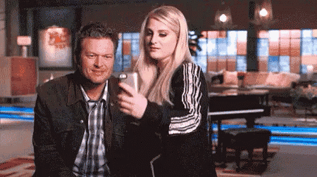 a man and a woman are taking a picture of themselves with a cell phone .