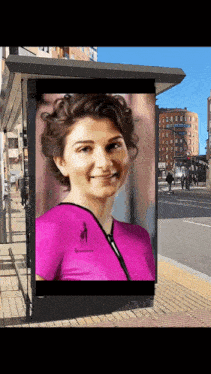 a picture of a woman in a pink shirt is on a billboard