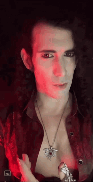 a man wearing a red shirt and a necklace with a dragon pendant