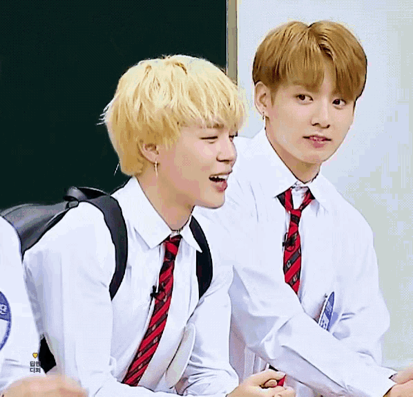 two boys wearing white shirts and red ties are smiling